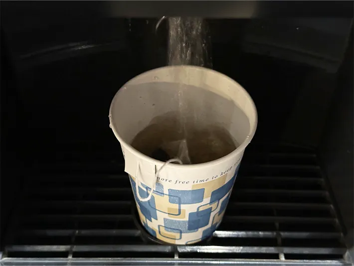 紙コップの縁にタグを挟んだ状態でお湯を注いでいる画像（撮影：grapeライフハック編集部）