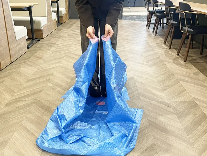 広げたレジャーシートの端を持つ写真（撮影：grapeライフハック編集部）