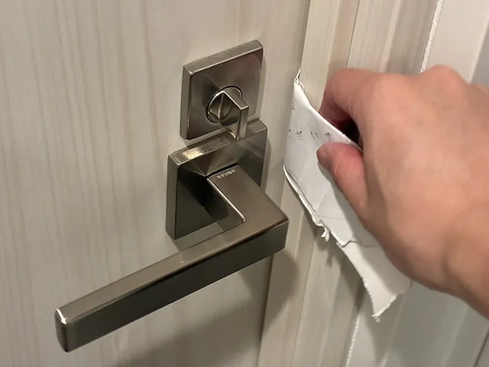 ドアノブに破ったトイレットペーパーの芯を差し込む場面（撮影：grapeライフハック編集部）