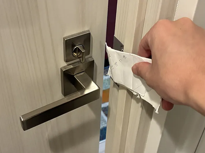 破ったトイレットペーパーの芯でドアを開けた場面（撮影：grapeライフハック編集部）