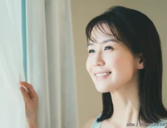 窓を開ける女性の写真