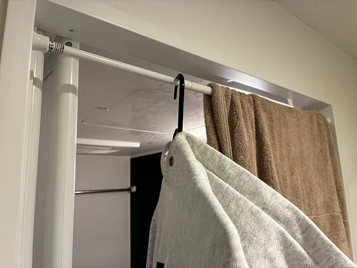 突っ張り棒で干すバスタオルとパーカー（撮影：grapeライフハック編集部）