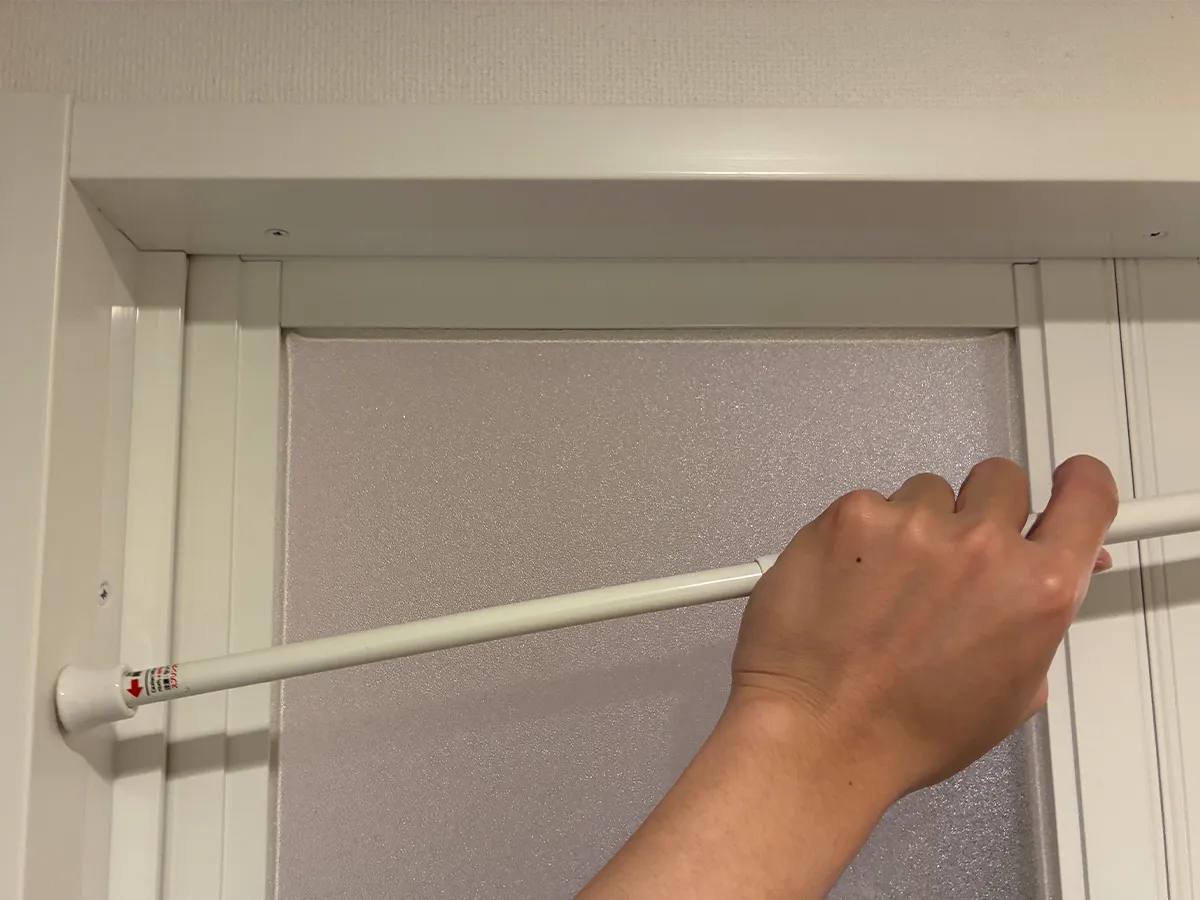 突っ張り棒を設置する場面（撮影：grapeライフハック編集部）