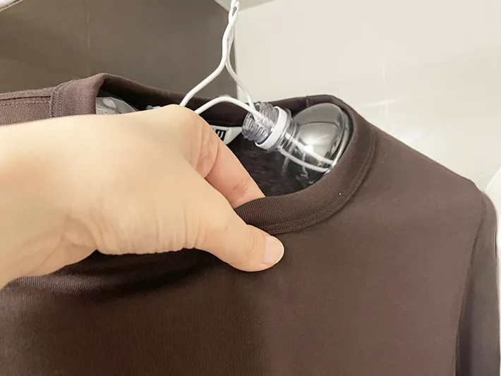 ペットボトルハンガーで干したTシャツを触っている写真（撮影：grapeライフハック編集部）