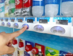 自動販売機でジュースを購入する手元