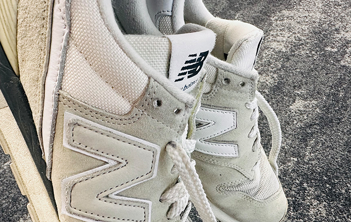 ニューバランスのスニーカーを手に取り二段ハトメに注目している写真