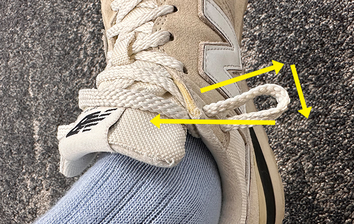 輪っかを作りながら二段ハトメの二段目まで靴紐を通あいている写真