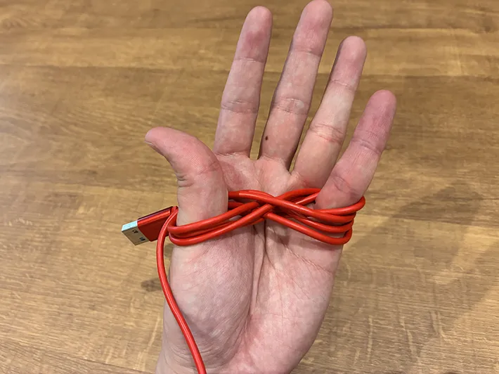 親指と小指に巻いた充電ケーブル（撮影：grapeライフハック編集部）