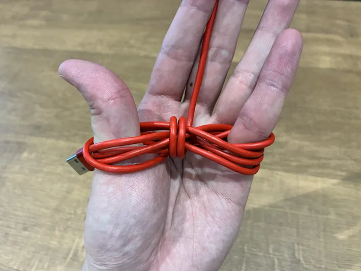 親指と小指に巻いた充電ケーブル（撮影：grapeライフハック編集部）