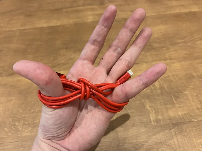親指と小指に巻いた充電ケーブル（撮影：grapeライフハック編集部）
