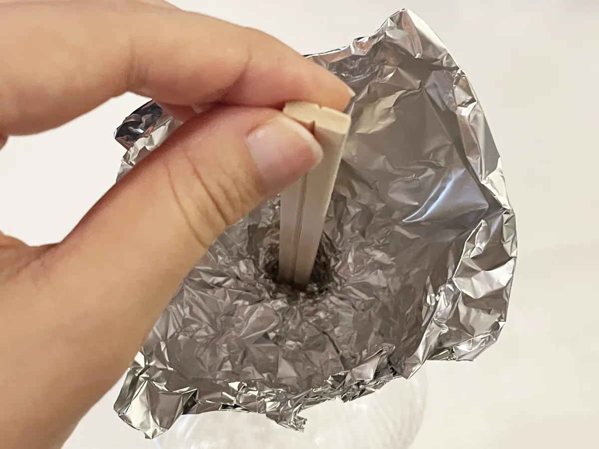 アルミホイル漏斗に割り箸で穴をあける写真（撮影：grapeライフハック編集部）