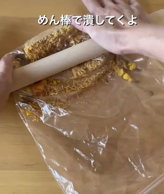 ビニール袋に入れたカップヌードルを砕いている様子