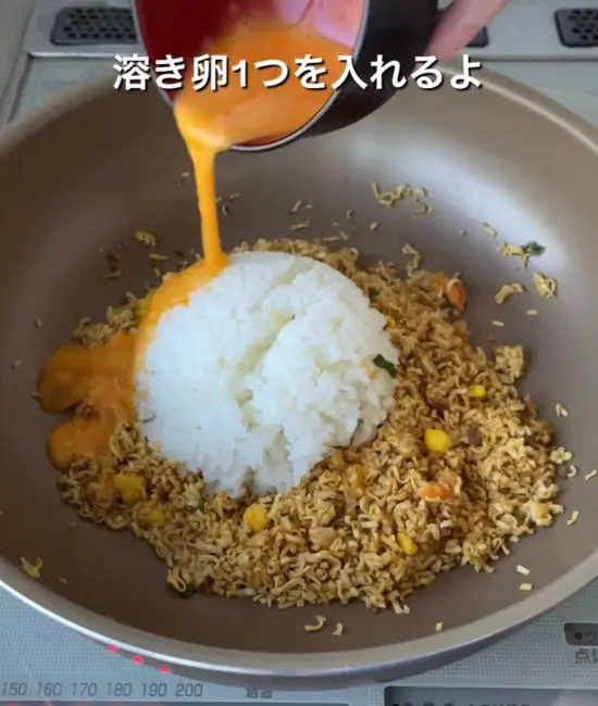 ご飯と卵を加えて炒め合わせている様子