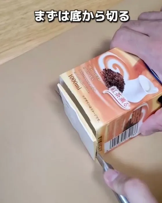 牛乳パックの底に包丁を入れている様子