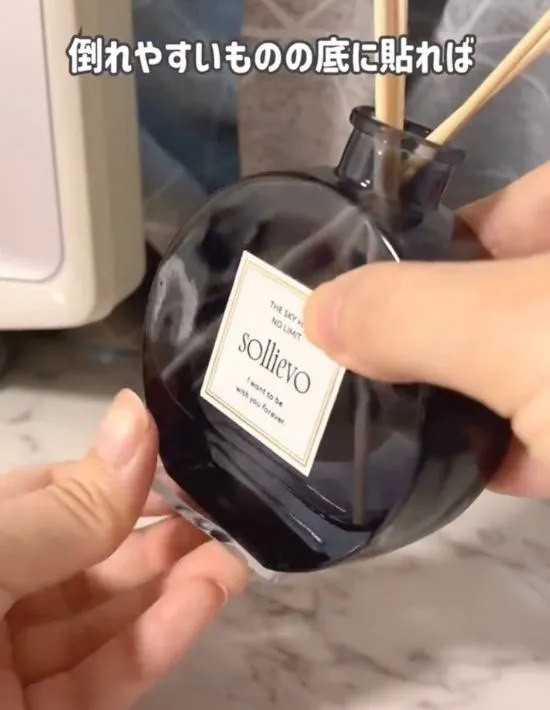 アロマディフューザーの裏に耐震マットを貼っている様子