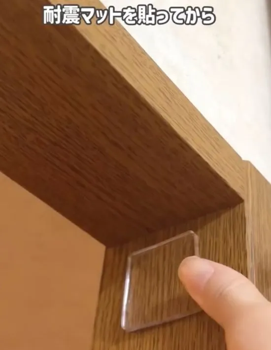 突っ張り棒を設置したい場所に耐震マットを貼っている様子