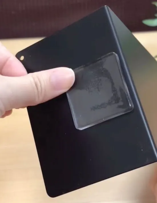 ブックエンドの裏に耐震マットを貼っている様子