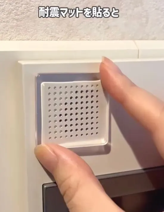 インターホンのスピーカー部分に耐震マットを貼っている様子