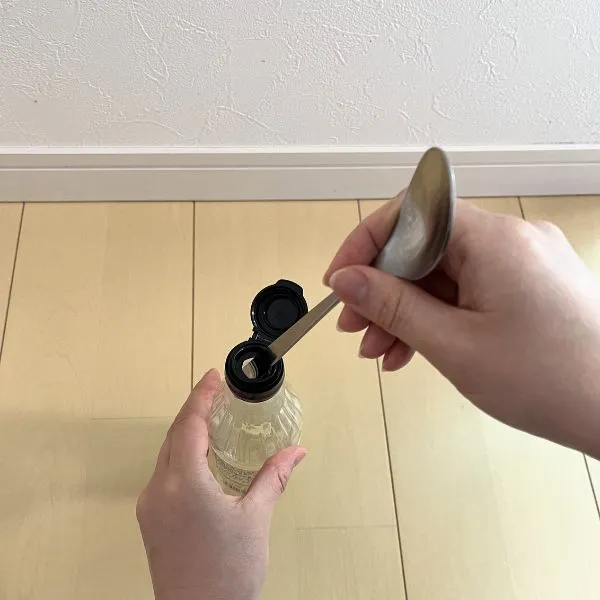 スプーンの柄をキャップに挿し込んでいる様子（撮影：grapeライフハック編集部）