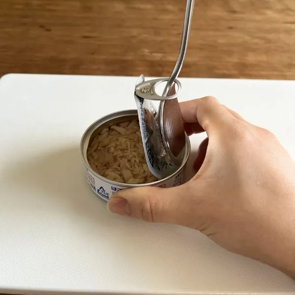 スプーンを使って缶詰を開けている様子（撮影：grapeライフハック編集部）