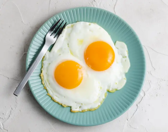 緑の皿にのった目玉焼き