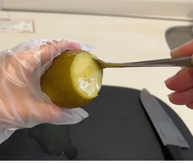 スプーンをキウイの皮と実の間に差し込んでいる様子（撮影：grapeフード編集部）