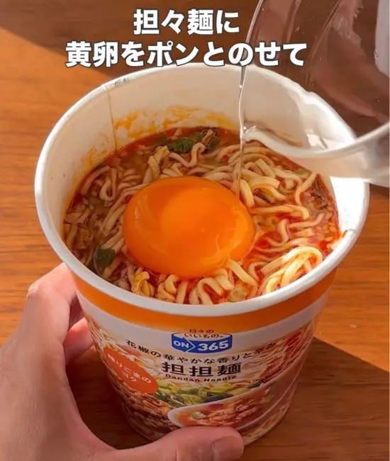 担々麺の上に卵黄をのせている様子