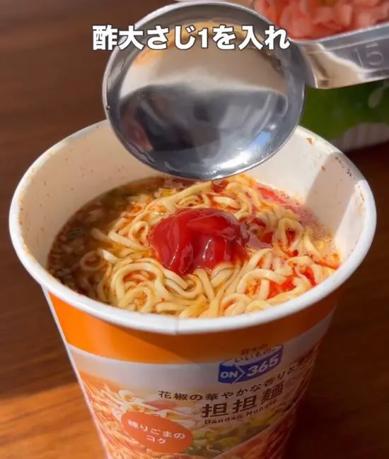 担々麺にケチャップとお酢を加えている様子