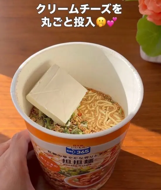 担々麺にクリームチーズを入れている様子
