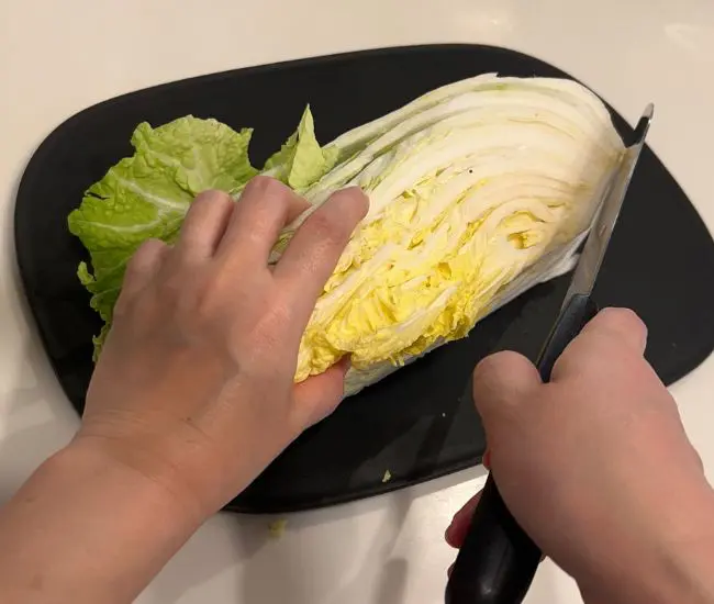 白菜の芯を包丁で斜めにカットしている様子（撮影：grapeフード編集部）