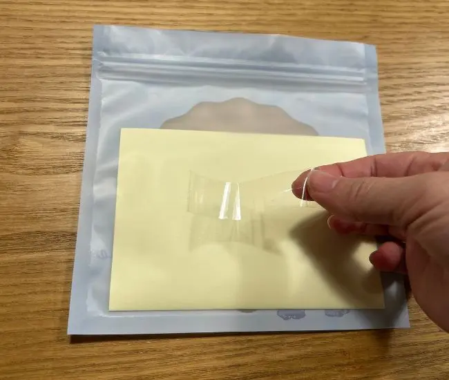 チャックつき保存袋にテープを貼っている様子（撮影：grapeライフハック編集部）