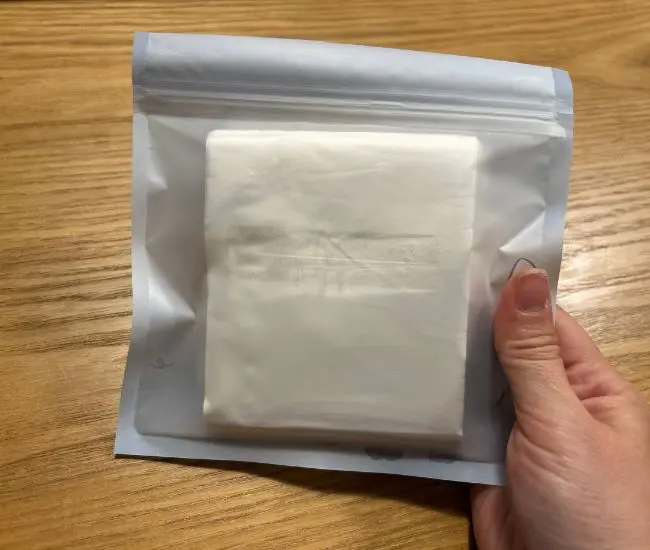 チャックつき保存袋にカットしたティッシュを入れている様子（撮影：grapeライフハック編集部）