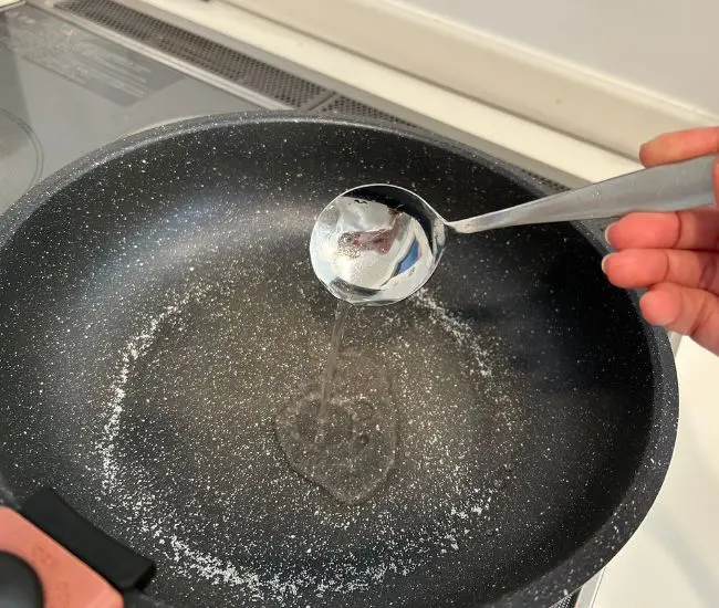 フライパンに塩と水を加えている様子（撮影：grapeフード編集部）