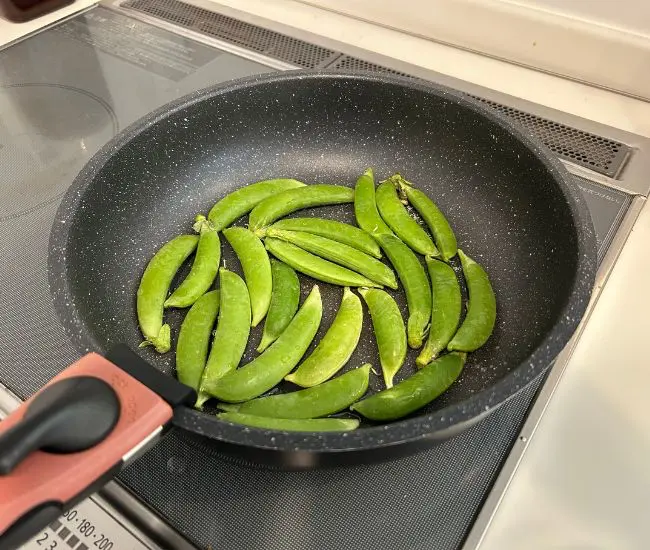 フライパンにスナップエンドウを並べている様子（撮影：grapeフード編集部）