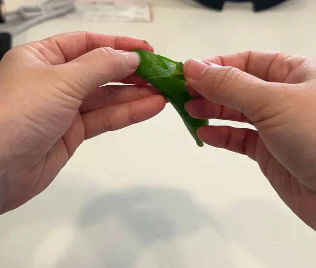 スナップエンドウの筋を取っている様子（撮影：grapeフード編集部）