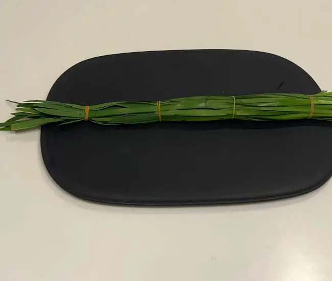 ニラを輪ゴムでまとめている様子（撮影：grapeフード編集部）