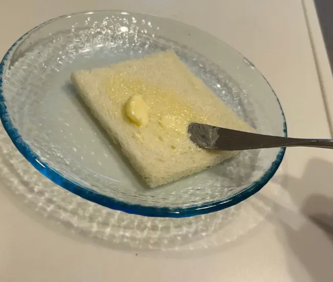 やわらかくなったバターを食パンに塗っている様子（撮影：grapeフード編集部）