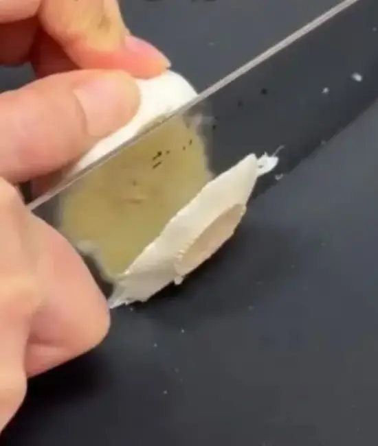 ニンニクの下部分を切り落としている様子