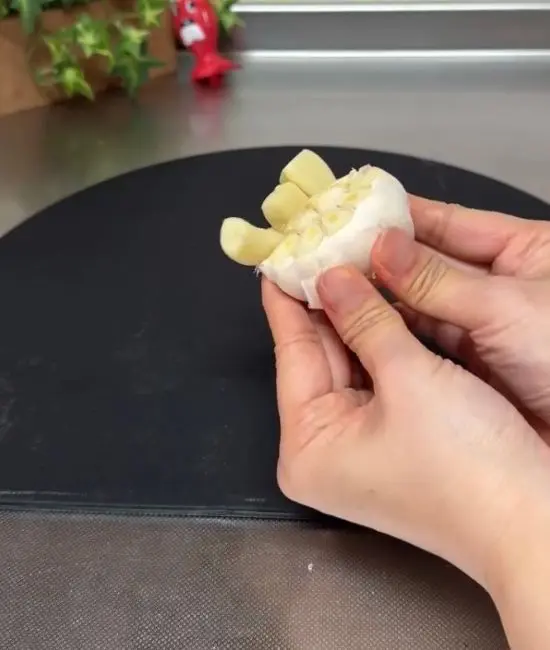 加熱後のニンニクを手で押し出している様子