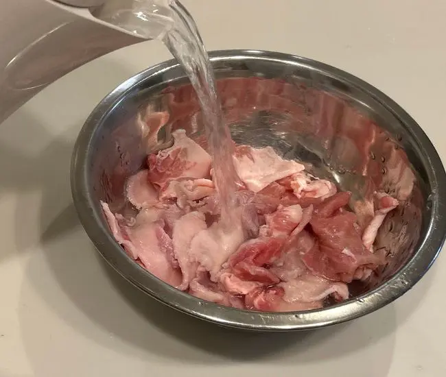豚こま肉に熱湯をかけている様子（撮影：grapeフード編集部）