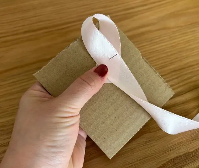 リボンを折り返してまち針に通している様子（撮影：grapeライフハック編集部）