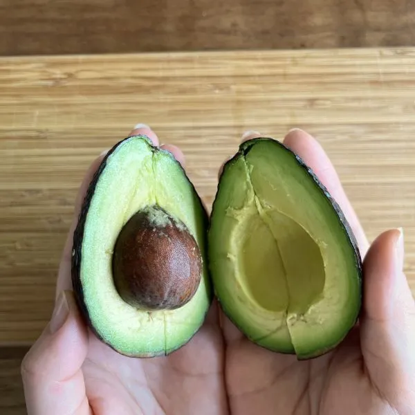 アボカドをねじって半分に分けている様子（撮影：grapeフード編集部）