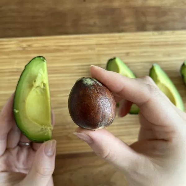 4等分にしたアボカドから種を外している様子（撮影：grapeフード編集部）
