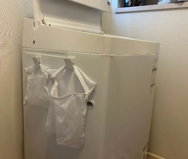 洗濯ネットを洗濯機に貼りつける様子（撮影：grapeライフハック編集部）