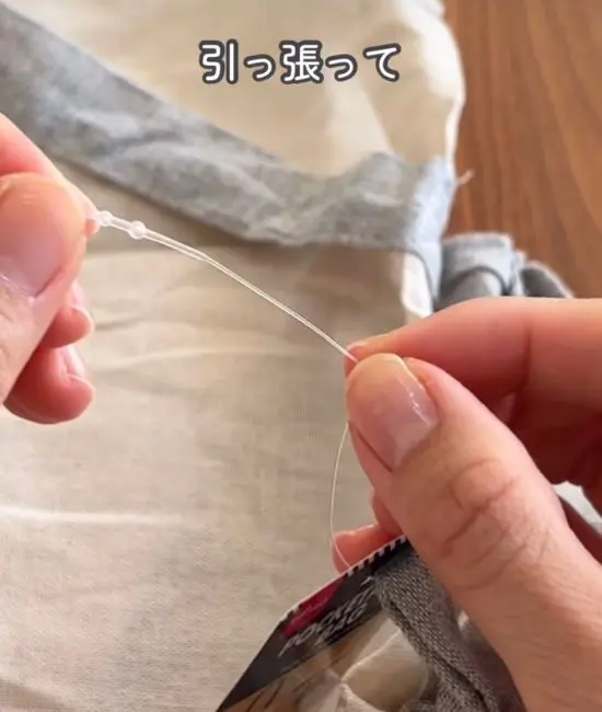 紐の先端を引っ張る様子