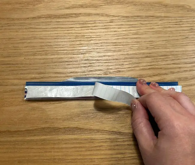 ジッパー部分をお菓子の袋に貼りつける様子（撮影：grapeフード編集部）