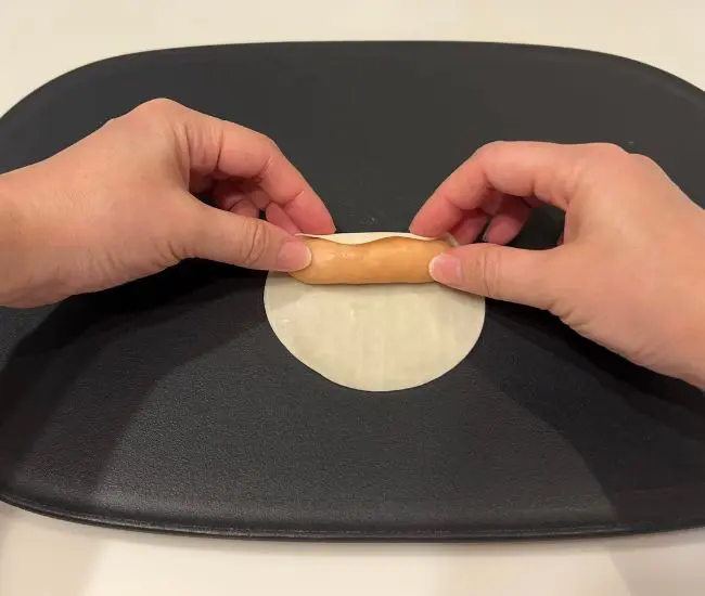 ソーセージを餃子の皮で巻いている様子（撮影：grapeフード編集部）