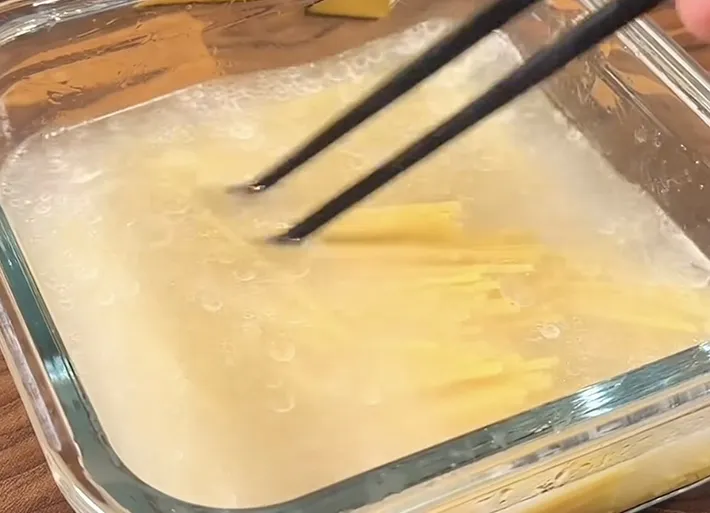パスタ麺を水と油にしっかりからませている画像