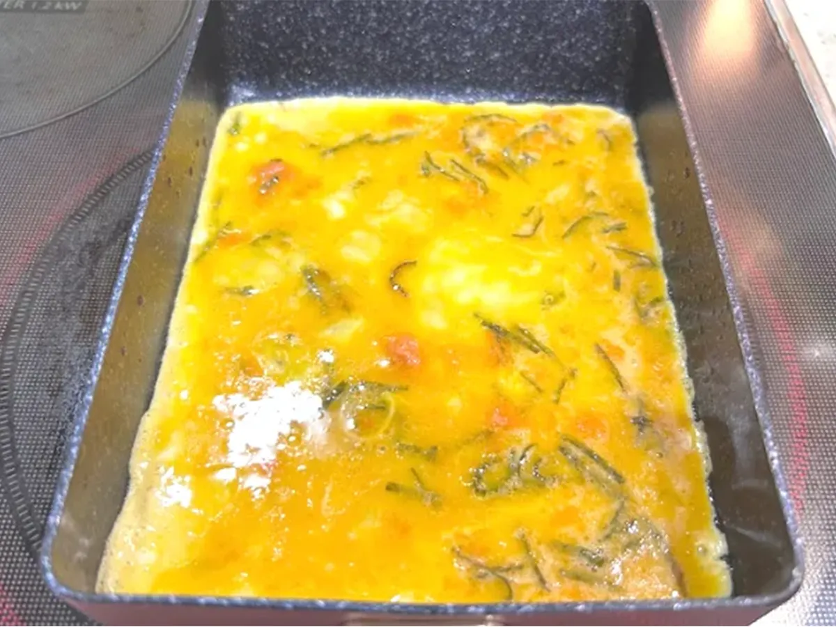 フライパンに玉子焼きの卵液を入れた場面（撮影：エニママ）