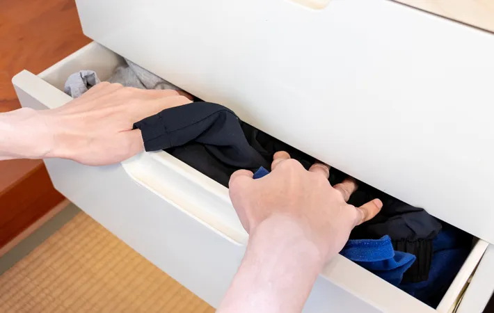 『服をドレッサーの引き出しに押し込む』写真